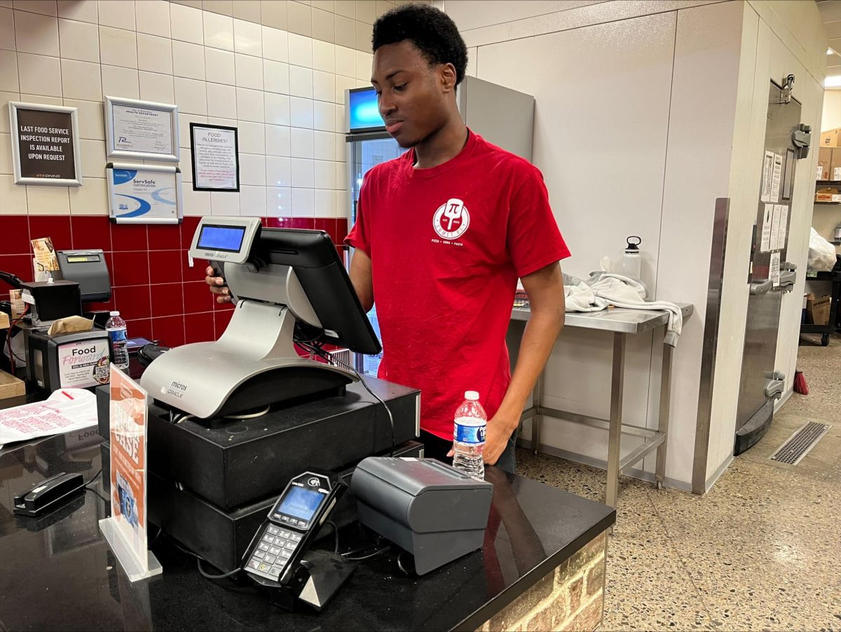 Freshman Mohammed Kouyate runs the cash register for the Comet Pi restaurant.